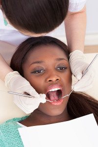 Dentist Examining the Mouth of a Young Woman During a Dental Appointment
